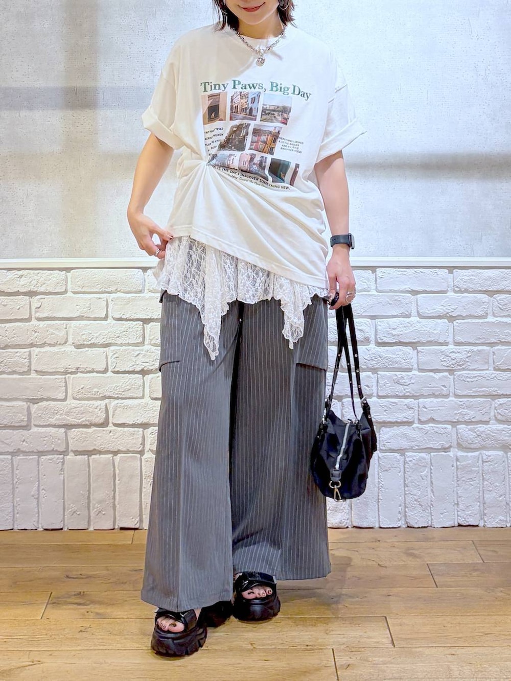 ブラック系のサンダル、ホワイト系のTシャツ/カットソー、ブラック系のトートバッグを着用したレディースの夏コーディネートの3枚目の写真
