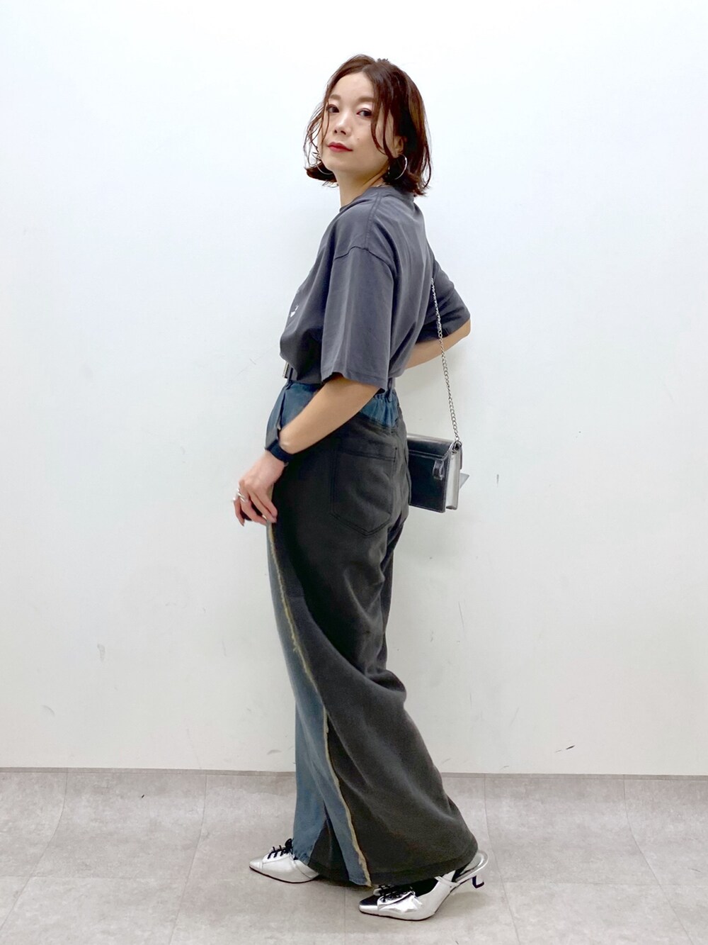 ブルー系のデニムパンツ、グリーン系のパンプス、ブラック系のテーラードジャケットを着用したレディースの秋コーディネートの4枚目の写真