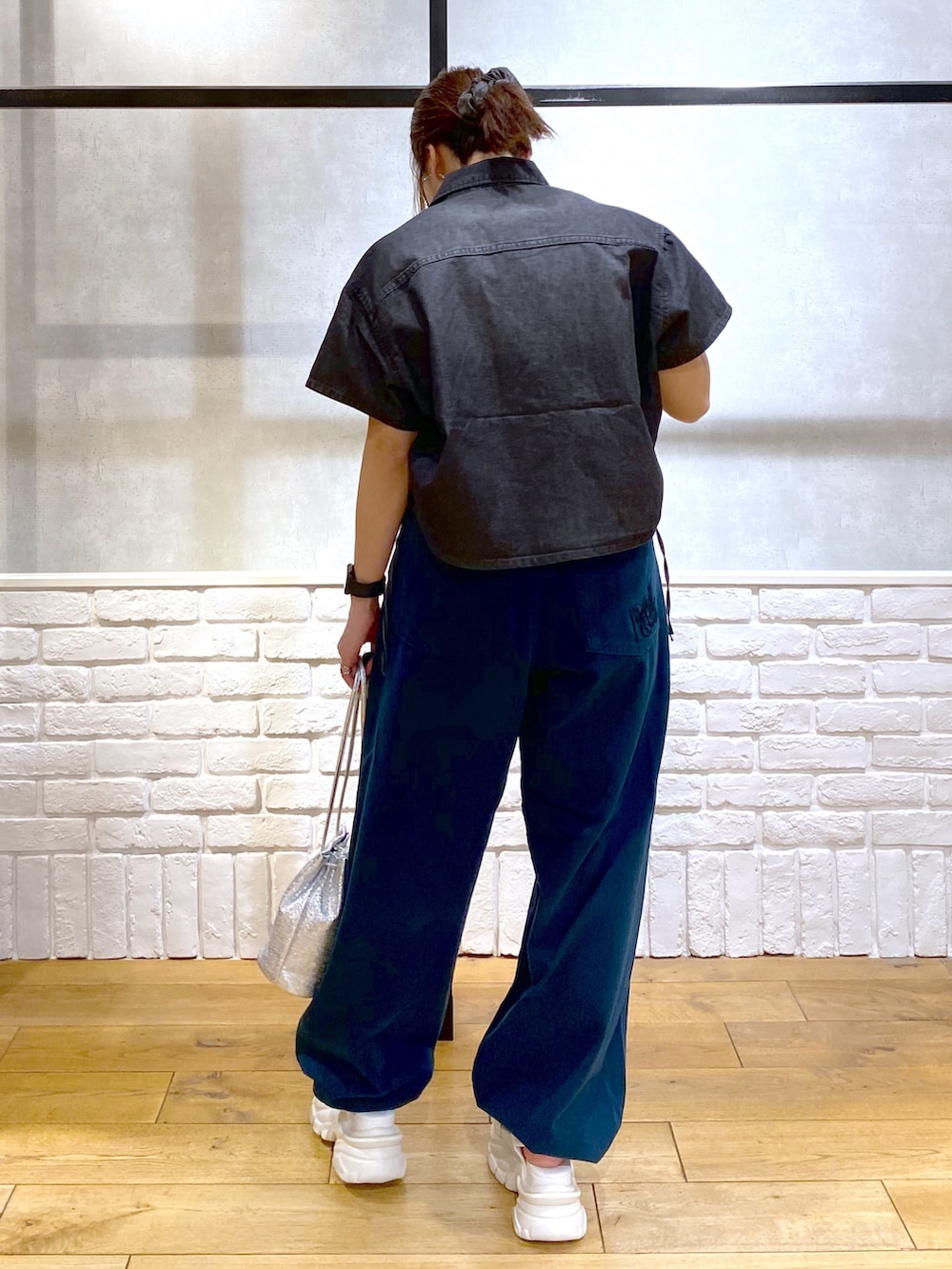 ホワイト系のタンクトップ、ブルー系のチノパンツ、ホワイト系のサンダルを着用したレディースの春コーディネートの6枚目の写真