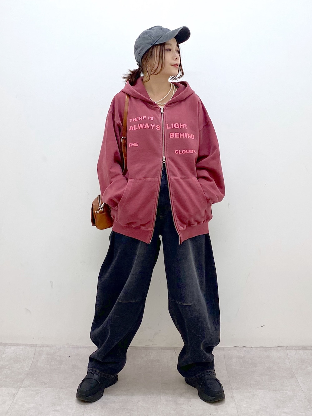 レッド系のスウェット、ブラック系のデニムパンツ、ブラック系のローファーを着用したレディースの冬コーディネートの8枚目の写真