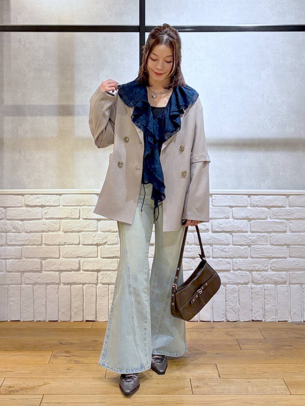 ブラック系のキャミソール、ブルー系のデニムパンツ、ブラウン系のハンドバッグを着用したレディースの春コーディネートの8枚目の写真