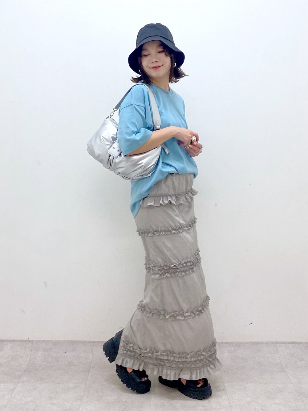 ブルー系のTシャツ/カットソー、シルバー系のショルダーバッグ、グレー系のスカートを着用したレディースの夏コーディネートの4枚目の写真