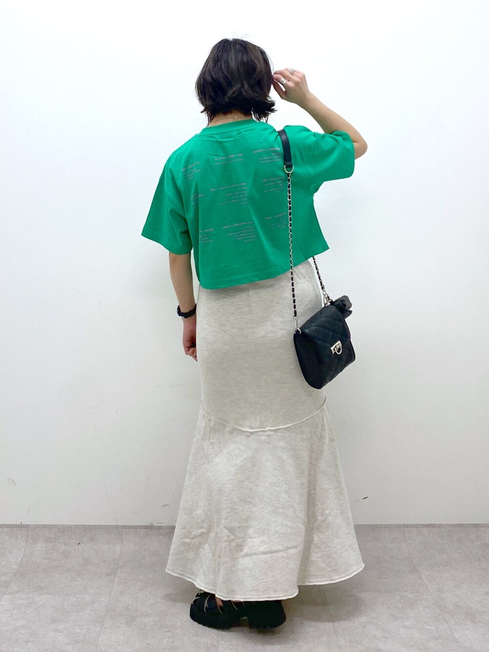 ブラック系のバッグ、ブラック系のサンダル、ベージュ系のスカートを着用したレディースの春コーディネートの4枚目の写真