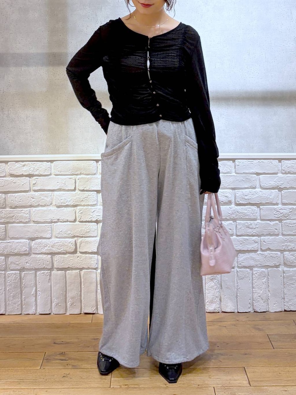 ホワイト系のキャミソール、ピンク系のハンドバッグ、グレー系のスウェットパンツを着用したレディースの春コーディネートの3枚目の写真