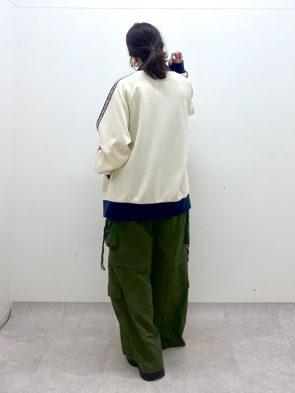 ブラック系のキャミソール、ホワイト系のセットアップ、グリーン系のカーゴパンツを着用したレディースの冬コーディネートの5枚目の写真