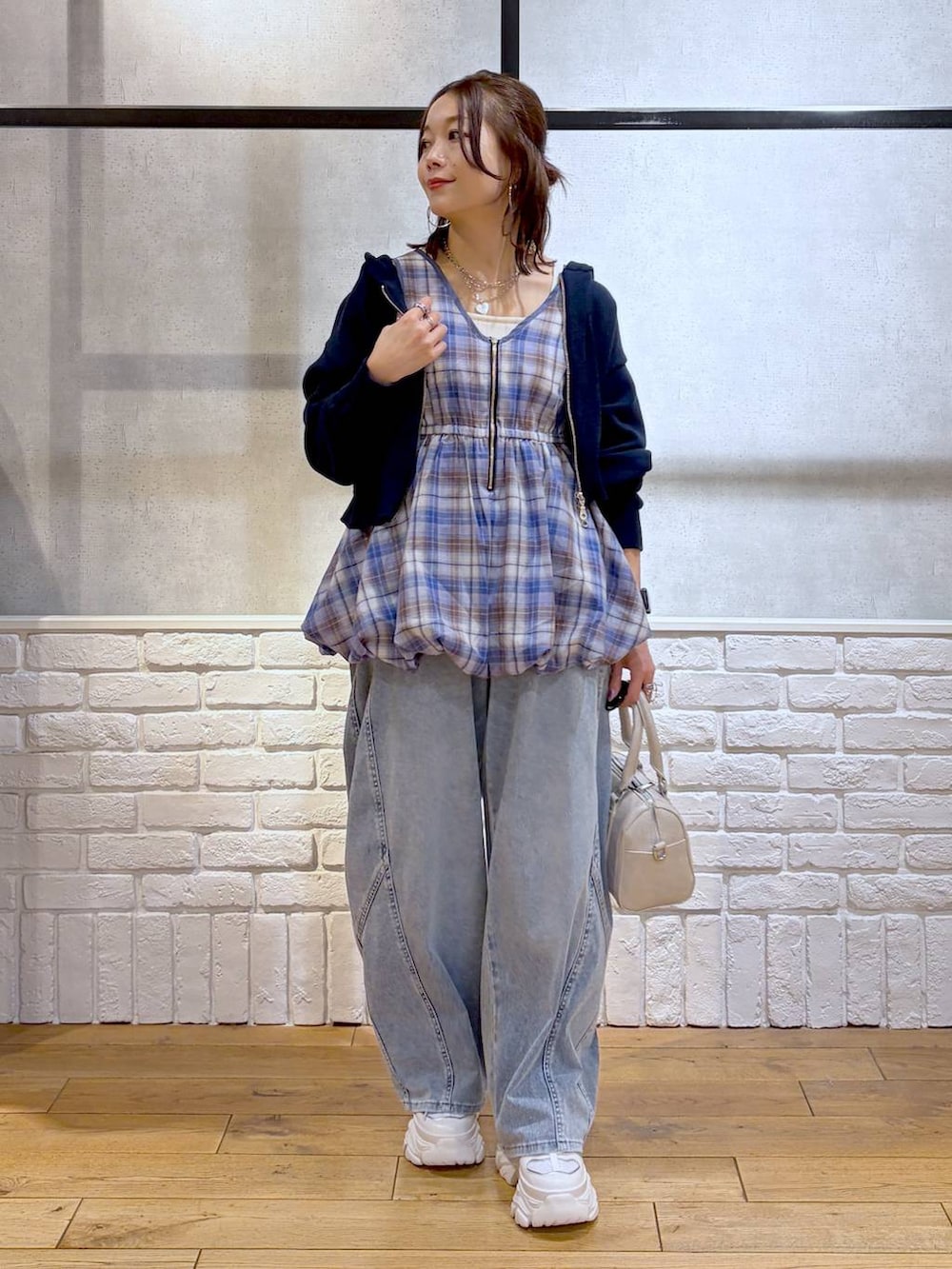 ホワイト系のスニーカー、ホワイト系のボストンバッグ、ブルー系のパーカーを着用したレディースの春コーディネートの9枚目の写真