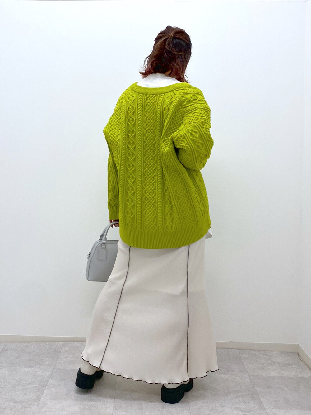 イエロー系のニット/セーター、ホワイト系のスカート、ホワイト系のローファーを着用したレディースの冬コーディネートの4枚目の写真