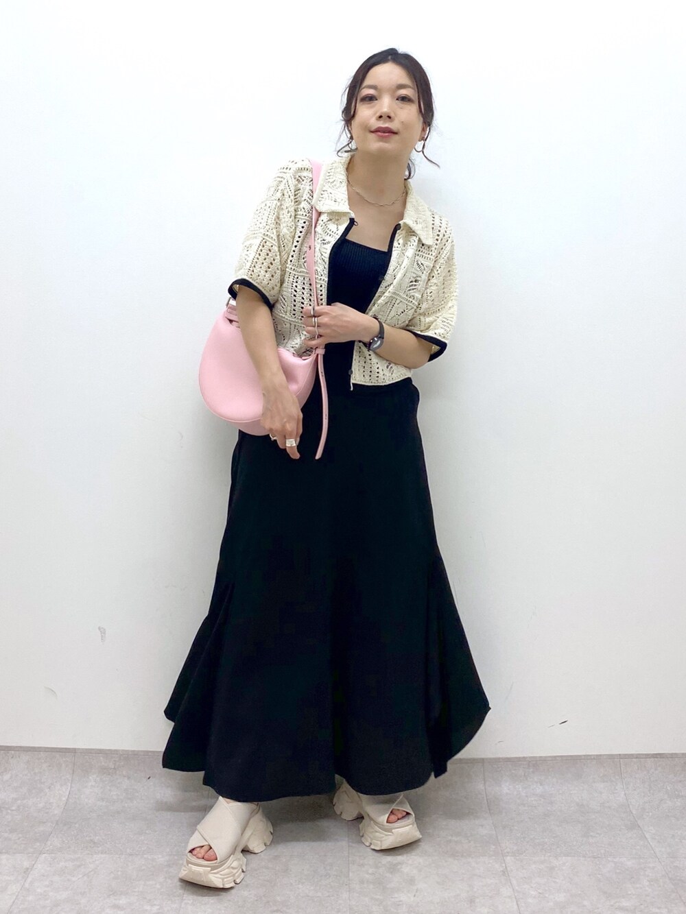 ブラック系のスカート、ホワイト系のカーディガン/ボレロ、ピンク系のショルダーバッグを着用したレディースの夏コーディネートの9枚目の写真