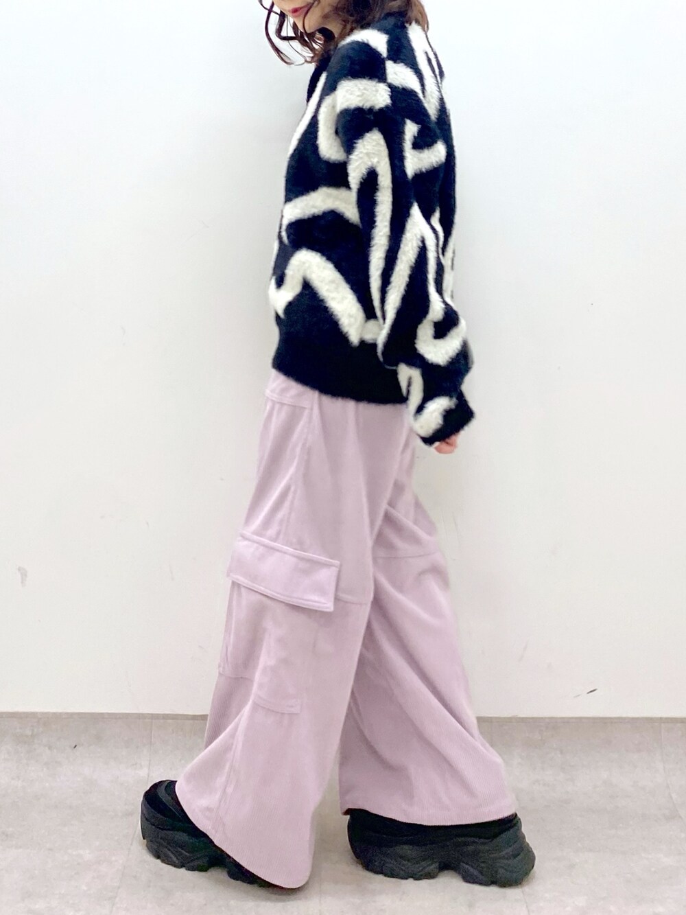 ピンク系のカーゴパンツ、ブラック系のニット/セーター、ブラック系のショルダーバッグを着用したレディースの冬コーディネートの7枚目の写真