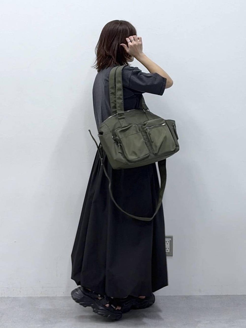 グリーン系のボストンバッグ、ブラック系のサンダル、ブラック系のスカートを着用したレディースの春コーディネートの7枚目の写真