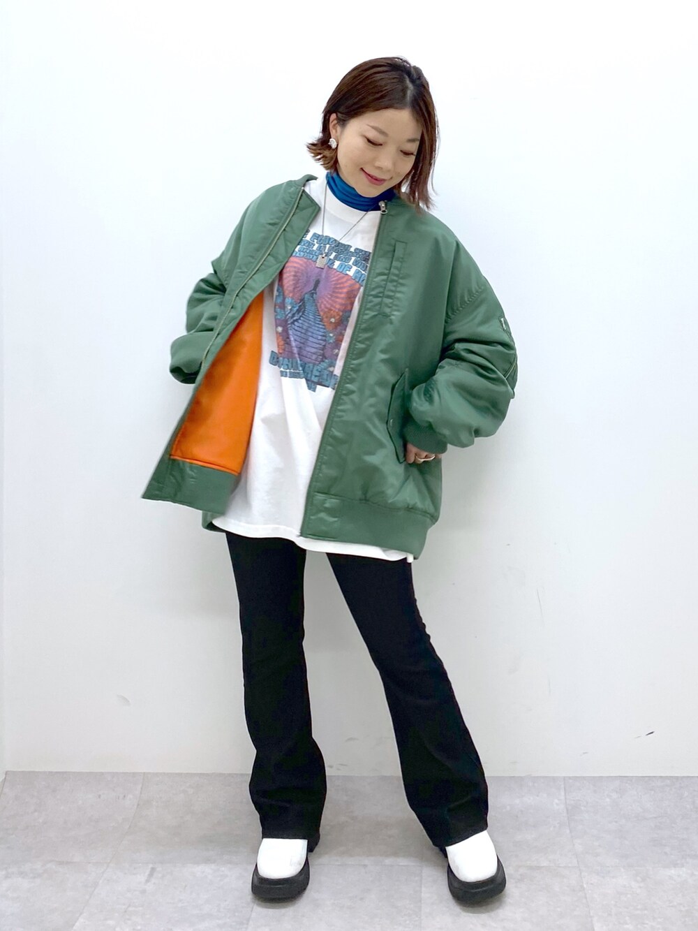 ブラック系のデニムパンツ、ホワイト系のシューズ、ブルー系のTシャツ/カットソーを着用したレディースの秋コーディネートの5枚目の写真