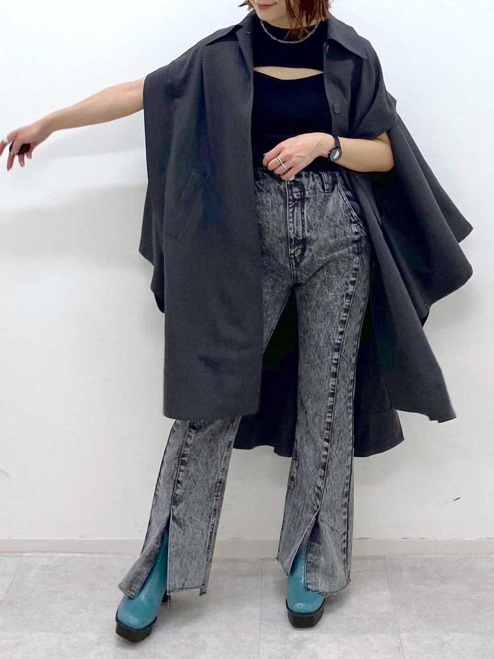 ブラック系のデニムパンツ、グレー系のポンチョ、ブラック系のトップスを着用したレディースの夏コーディネートの5枚目の写真