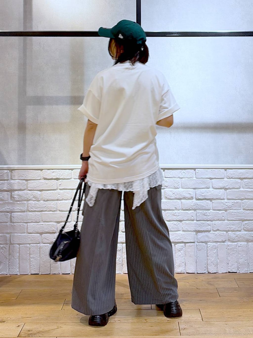 ブラック系のサンダル、ホワイト系のTシャツ/カットソー、ブラック系のトートバッグを着用したレディースの夏コーディネートの6枚目の写真