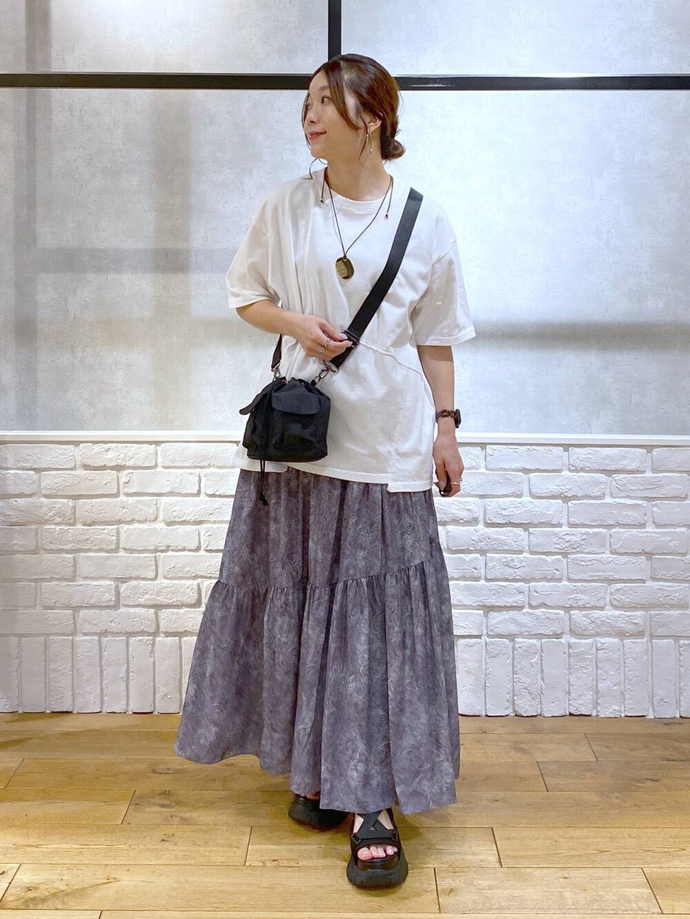 ブラック系のサンダル、ブラック系のショルダーバッグ、グレー系のスカートを着用したレディースの夏コーディネートの4枚目の写真