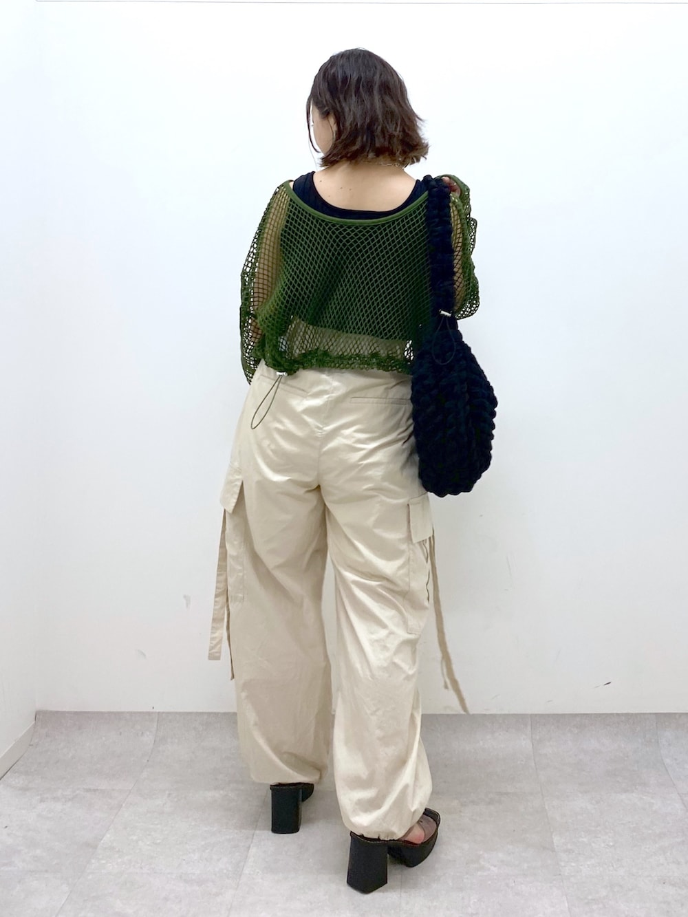 ホワイト系のカーゴパンツ、ブラック系のトップス、グリーン系のTシャツ/カットソーを着用したレディースの夏コーディネートの3枚目の写真
