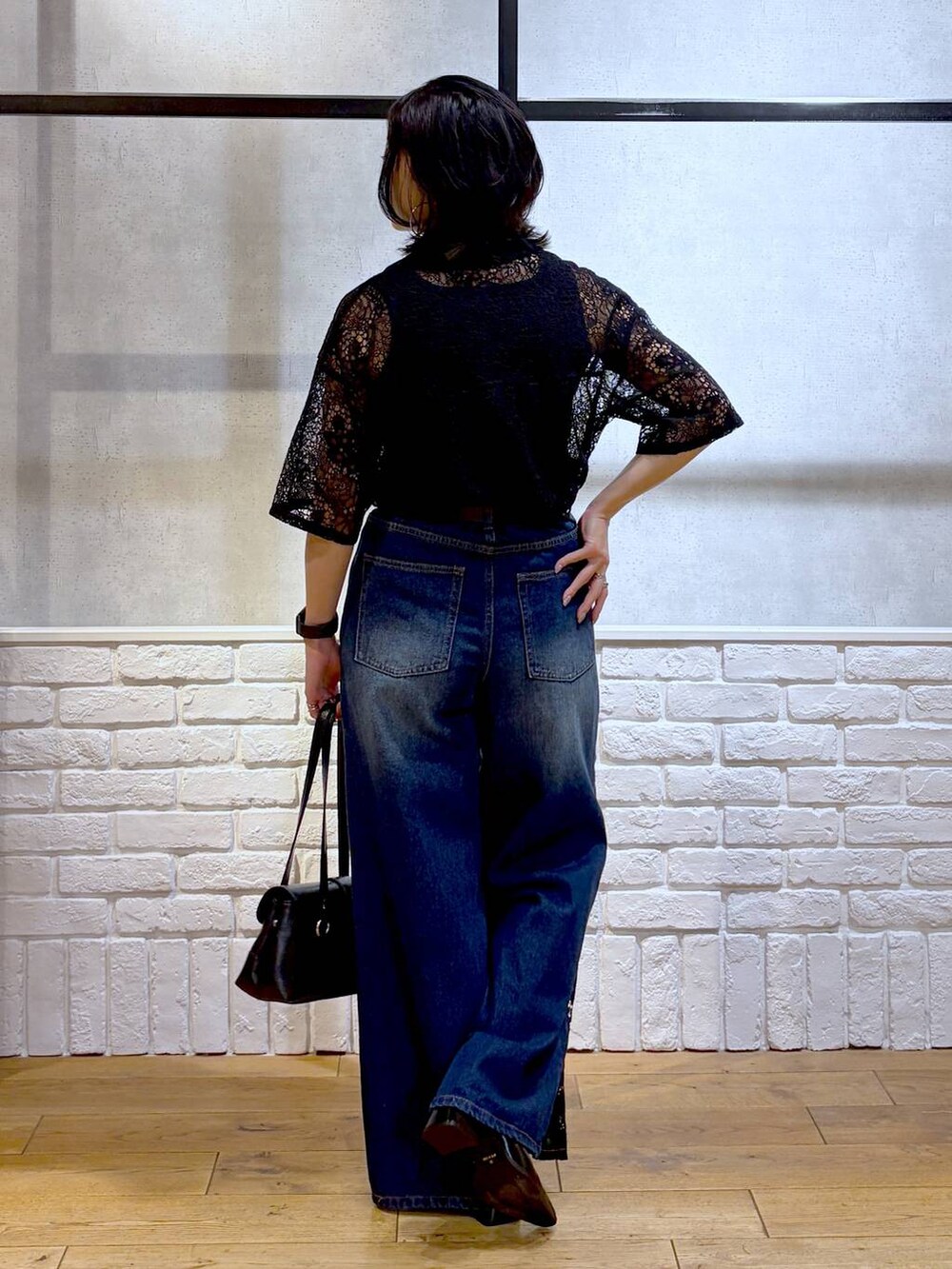 ブルー系のデニムパンツ、ブラック系のシャツ/ブラウス、ブラック系のショルダーバッグを着用したレディースの夏コーディネートの6枚目の写真