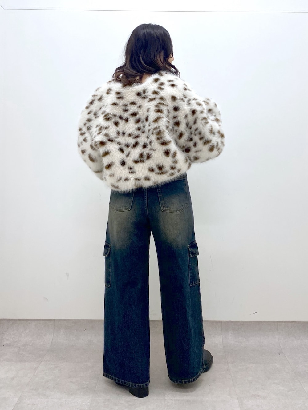 ブルー系のデニムパンツ、ブルー系のニット/セーター、ブラック系のブーツを着用したレディースの冬コーディネートの4枚目の写真