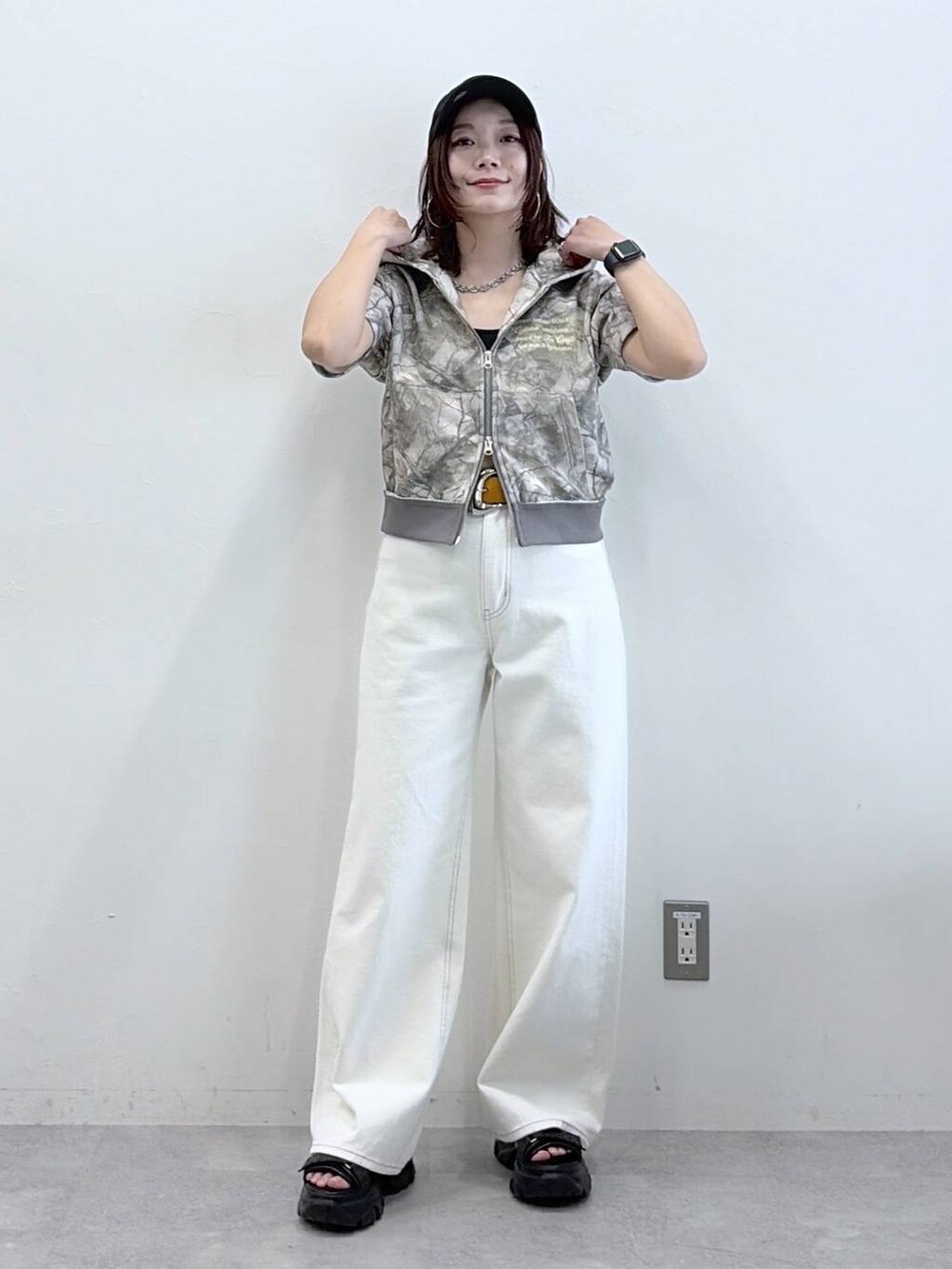 ホワイト系のデニムパンツ、ブラック系のサンダル、その他のパーカーを着用したレディースの春コーディネートの4枚目の写真