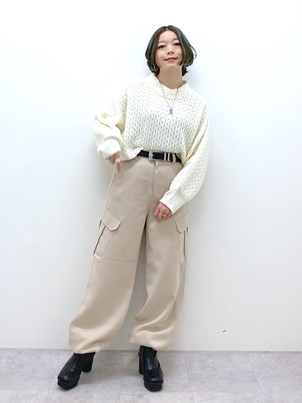 ブラック系のジャケット/アウター、ホワイト系のニット/セーター、ベージュ系のカーゴパンツを着用したレディースの冬コーディネートの5枚目の写真