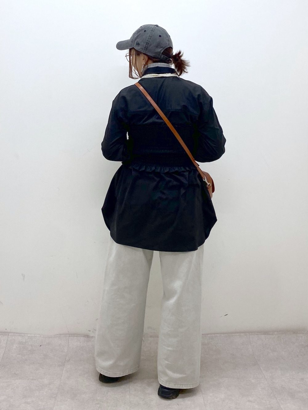 ブラック系のシャツ/ブラウス、ベージュ系のショルダーバッグ、グレー系のデニムパンツを着用したレディースの冬コーディネートの6枚目の写真