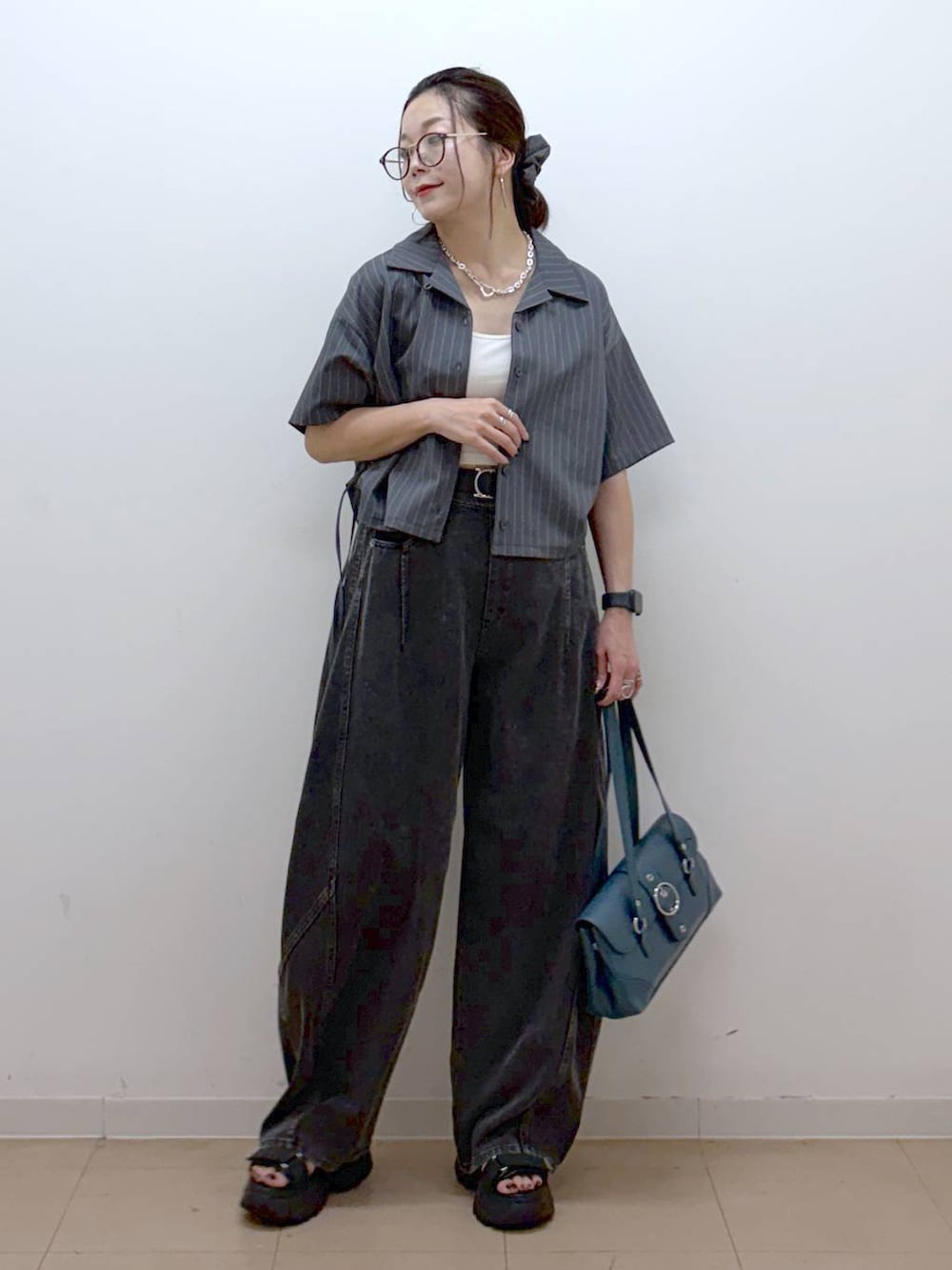 ブラック系のデニムパンツ、ブラック系のサンダル、グレー系のシャツ/ブラウスを着用したレディースの夏コーディネートの8枚目の写真