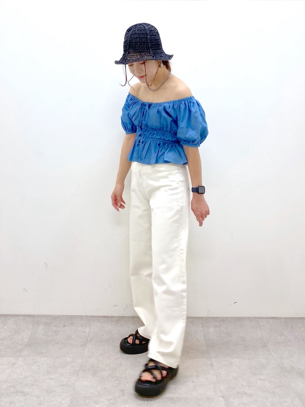 ブルー系のシャツ/ブラウス、ホワイト系のデニムパンツ、ブラック系のサンダルを着用したレディースの春コーディネートの4枚目の写真