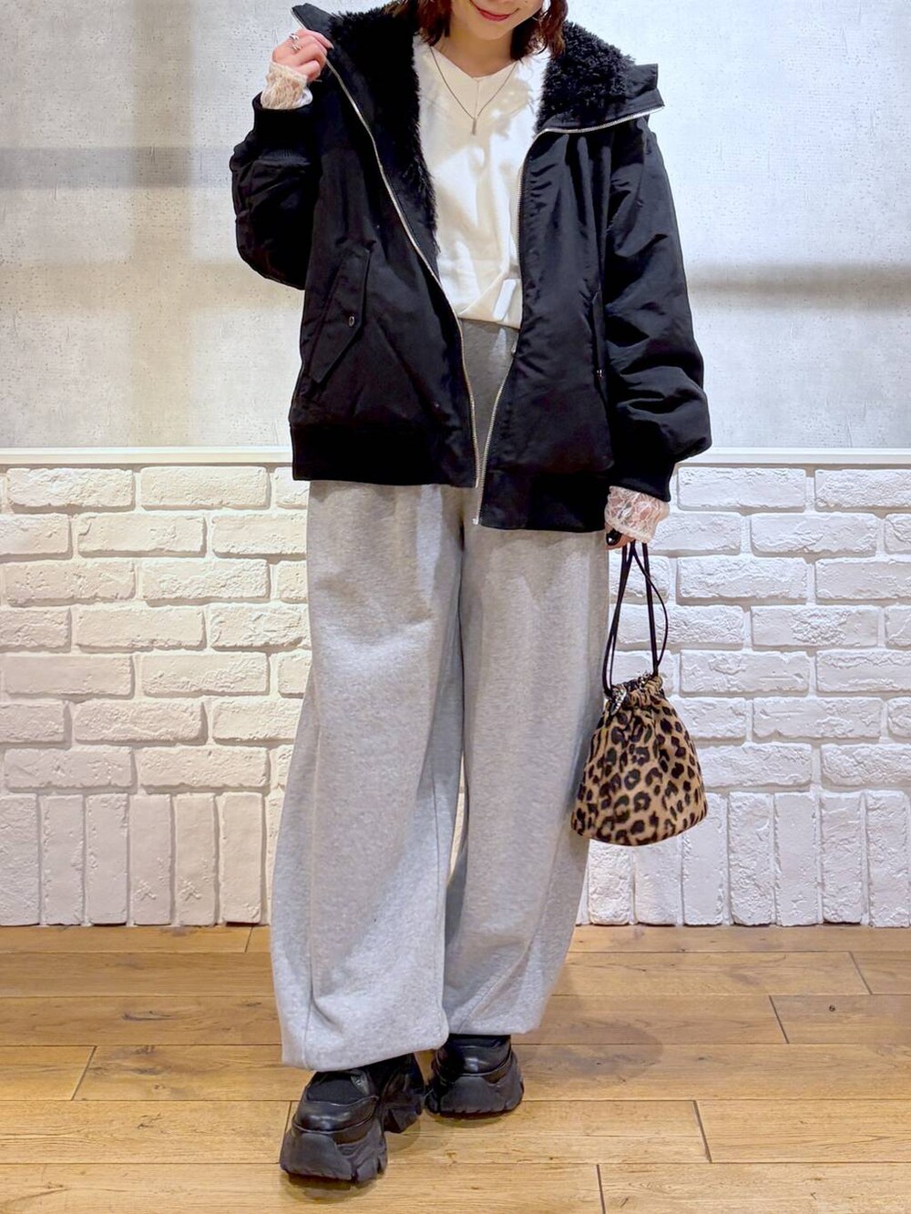ブラック系のブーツ、グレー系のスウェットパンツ、ブラック系のブルゾンを着用したレディースの冬コーディネートの2枚目の写真