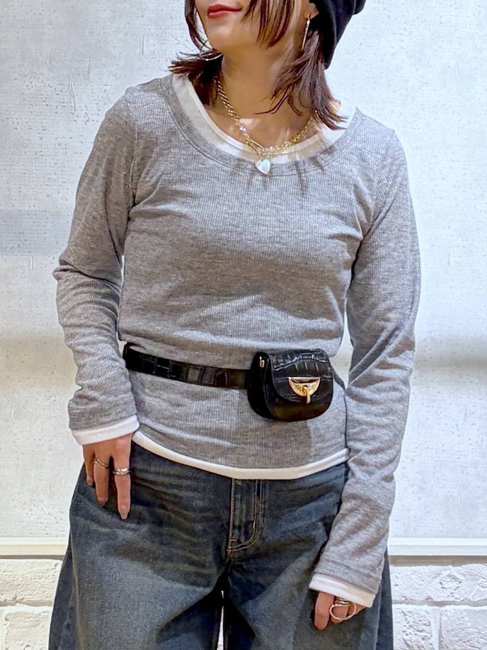 ホワイト系のスニーカー、ブラック系のボディバッグ/ウエストポーチ、ブルー系のデニムパンツを着用したレディースの春コーディネートの2枚目の写真