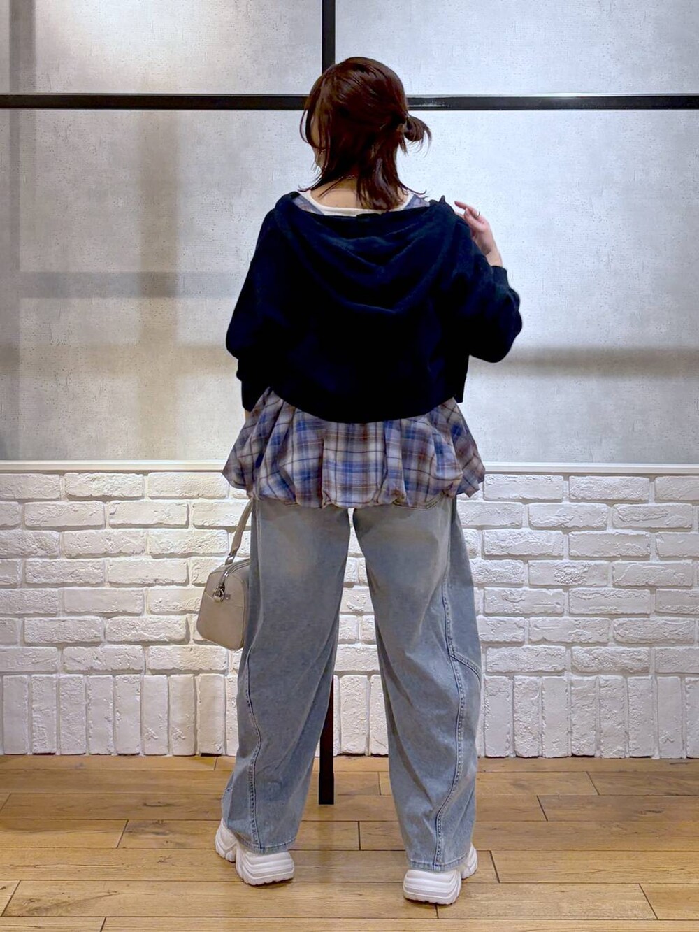 ホワイト系のスニーカー、ホワイト系のボストンバッグ、ブルー系のパーカーを着用したレディースの春コーディネートの6枚目の写真