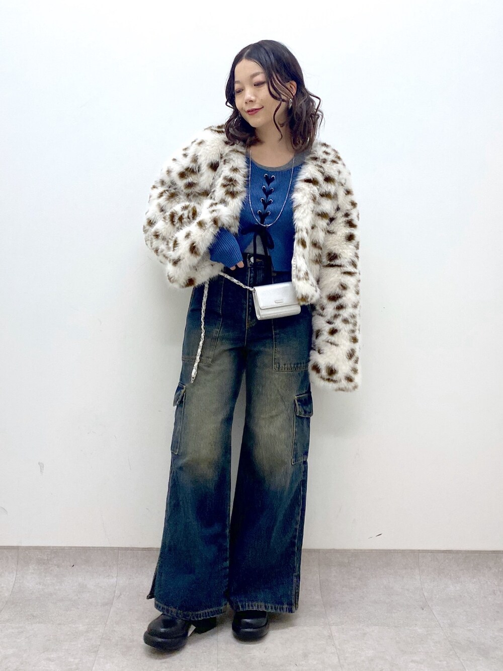 ブルー系のデニムパンツ、ブルー系のニット/セーター、ブラック系のブーツを着用したレディースの冬コーディネートの9枚目の写真