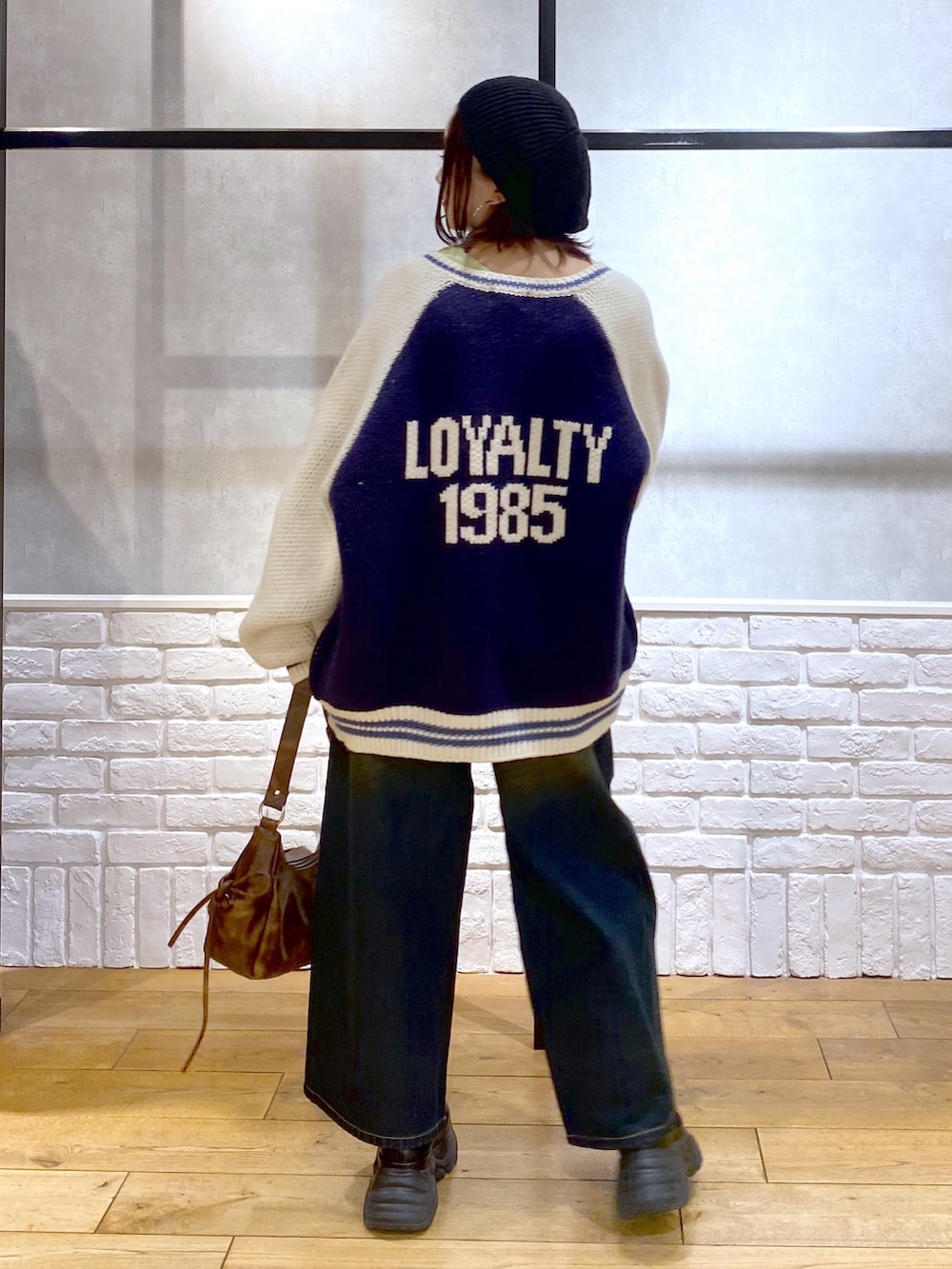 イエロー系のTシャツ/カットソー、ブラウン系のショルダーバッグ、ブルー系のデニムパンツを着用したレディースの冬コーディネートの7枚目の写真