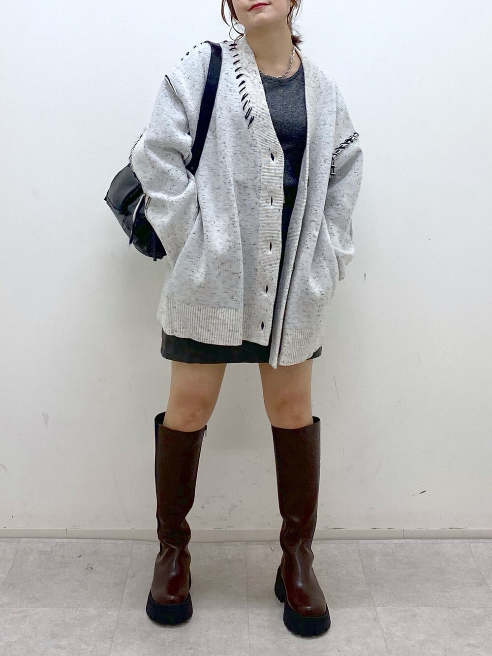 ホワイト系のニット/セーター、シルバー系のTシャツ/カットソー、ブラック系のスカートを着用したレディースの秋コーディネートの3枚目の写真