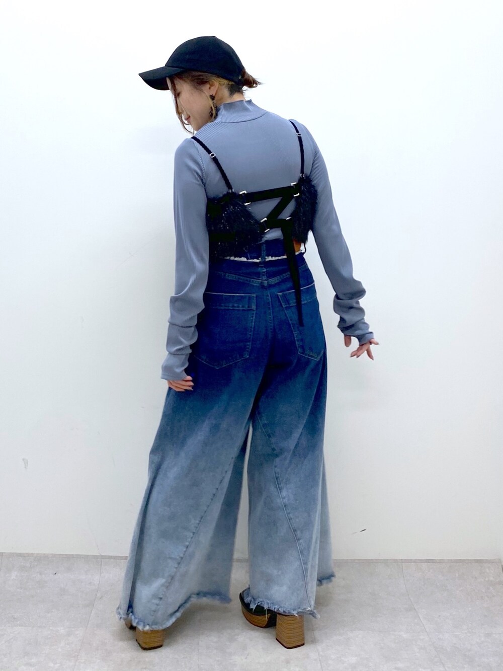 ブルー系のデニムパンツ、ブラック系のベスト、ブルー系のTシャツ/カットソーを着用したレディースの秋コーディネートの6枚目の写真