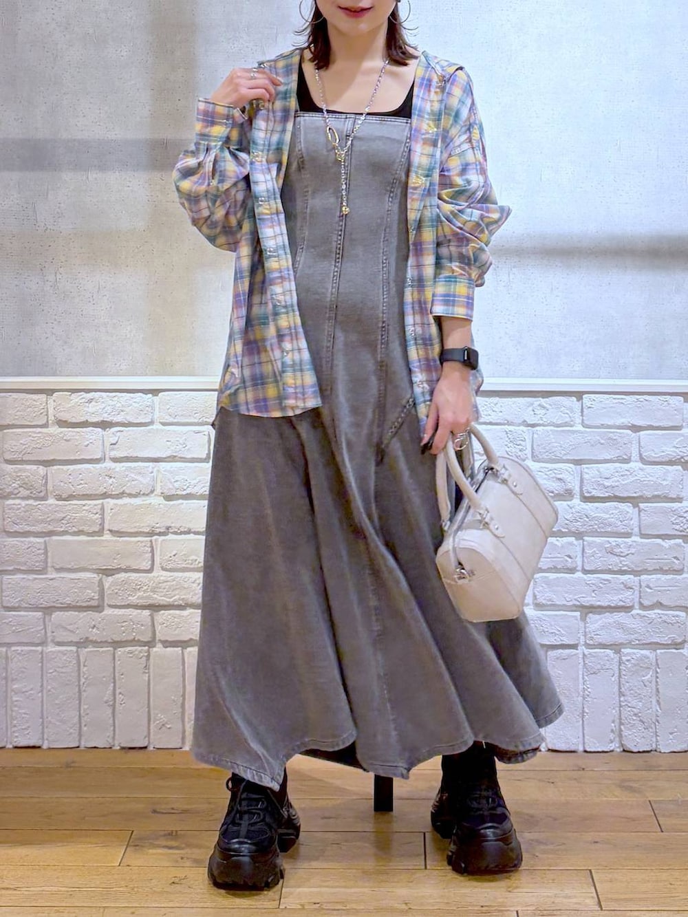 ブラック系のスニーカー、ホワイト系のボストンバッグ、ブラック系のワンピースを着用したレディースの春コーディネートの3枚目の写真