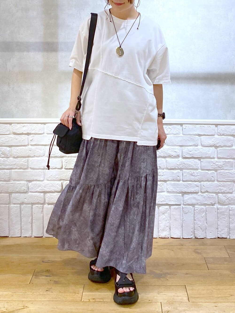 ブラック系のサンダル、ブラック系のショルダーバッグ、グレー系のスカートを着用したレディースの夏コーディネートの3枚目の写真