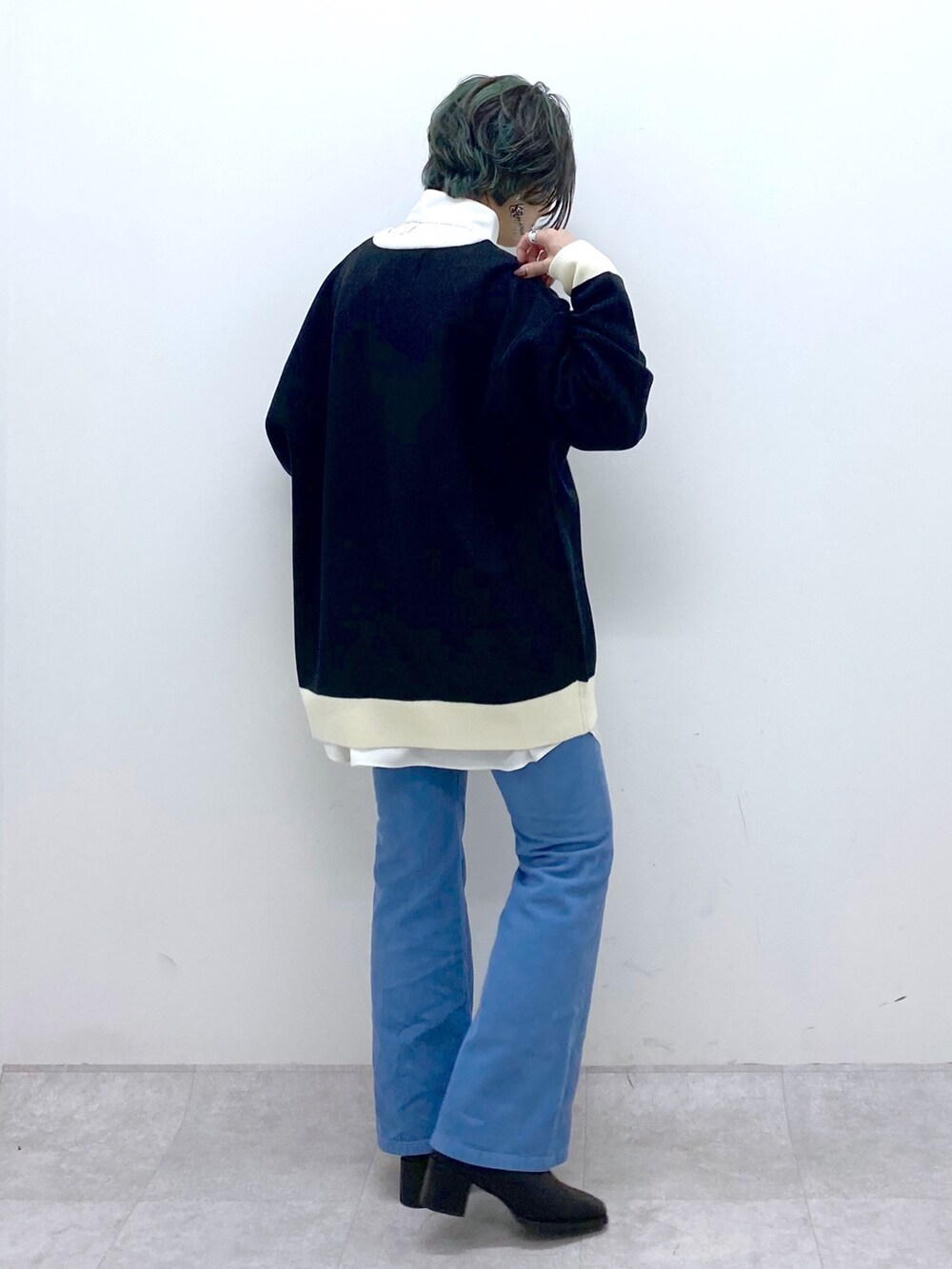 ブラック系のトップス、ホワイト系のトップス、ブルー系のパンツを着用したレディースの秋コーディネートの3枚目の写真