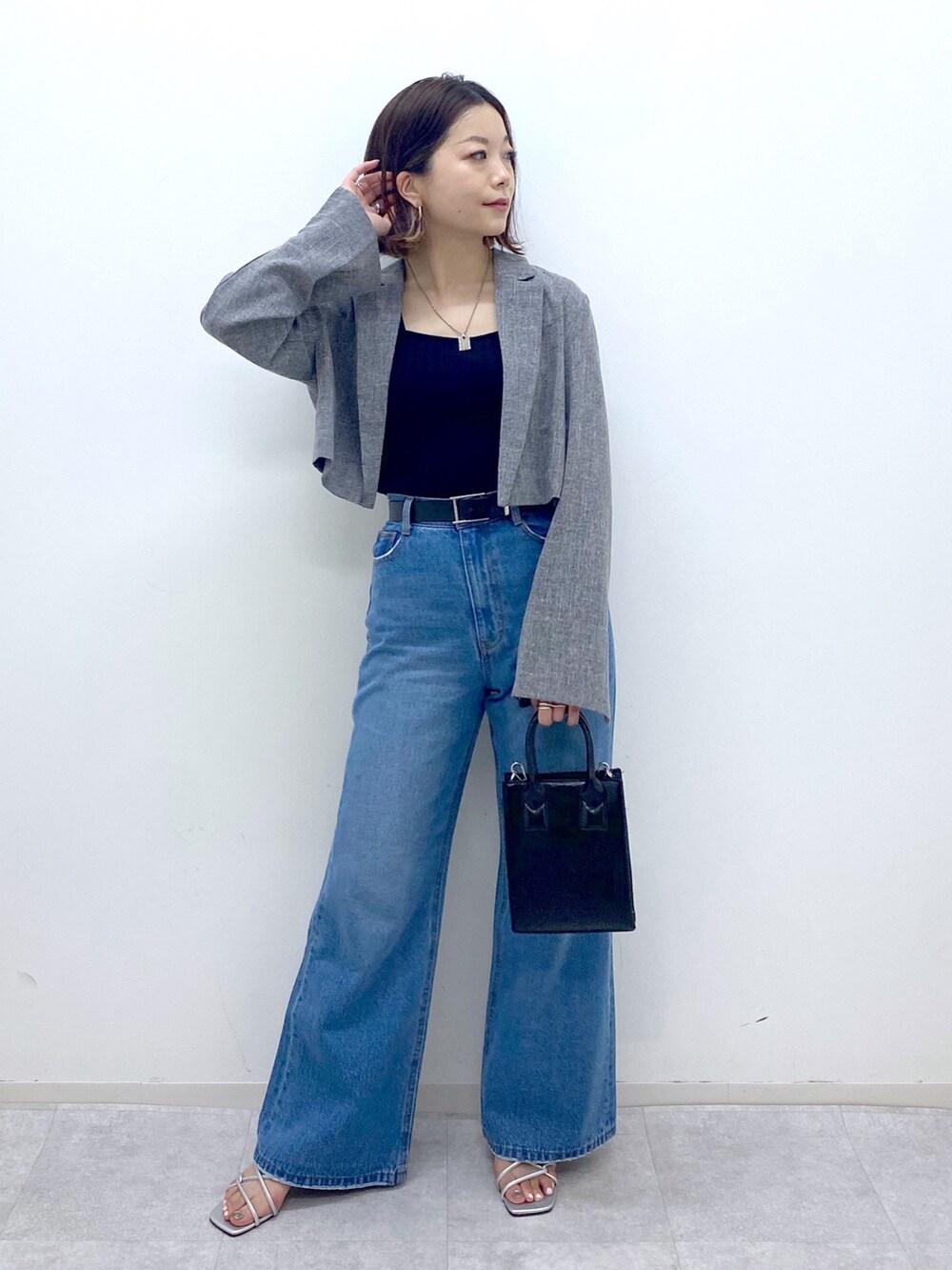 ブルー系のパンツ、グレー系のテーラードジャケット、シルバー系のサンダルを着用したレディースの夏コーディネートの2枚目の写真