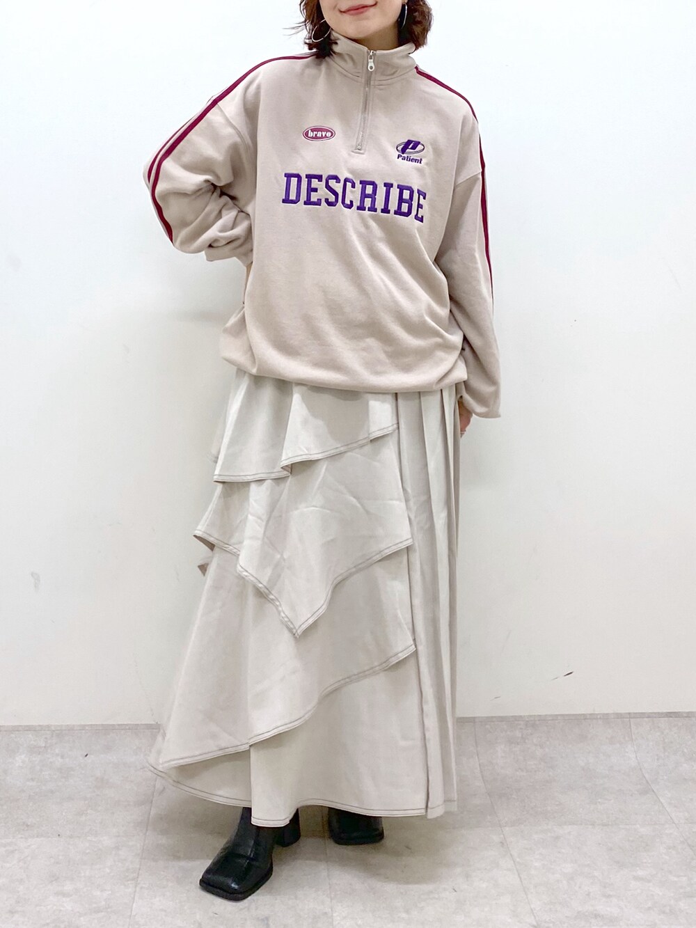 ベージュ系のスウェット、グレー系のスカート、ブラック系のブーツを着用したレディースの秋コーディネートの3枚目の写真