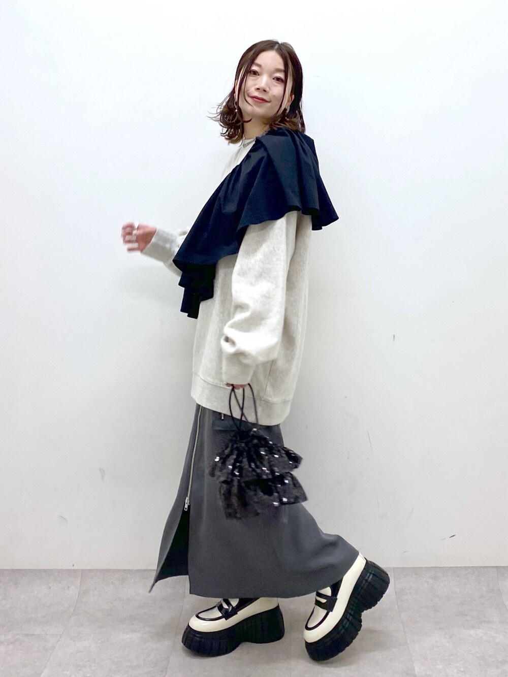 ベージュ系のスウェット、ブラック系のシャツ/ブラウス、ブラック系のショルダーバッグを着用したレディースの冬コーディネートの4枚目の写真