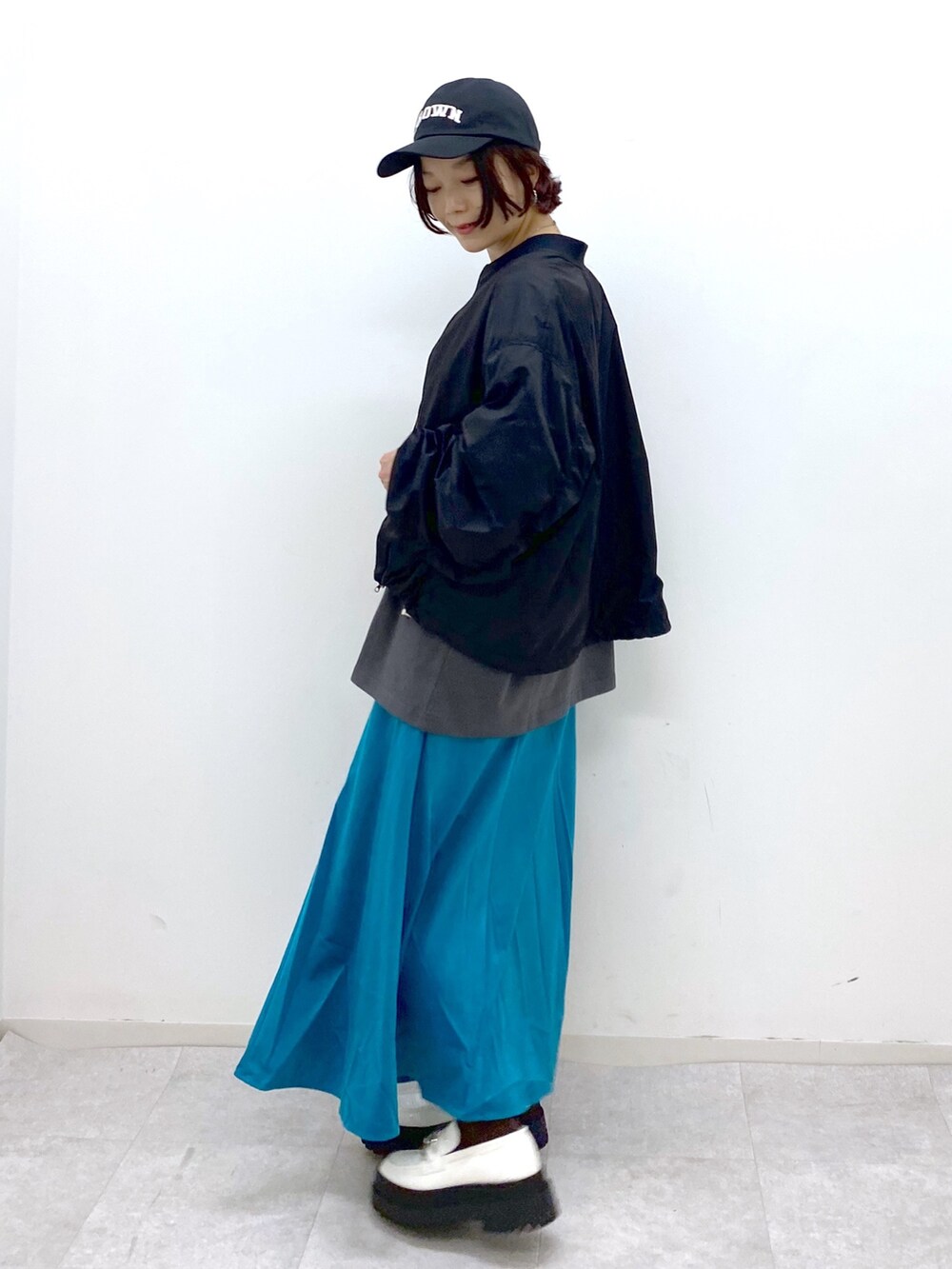 ブラック系のジャケット/アウター、ブラック系のトップス、グリーン系のスカートを着用したレディースの夏コーディネートの2枚目の写真