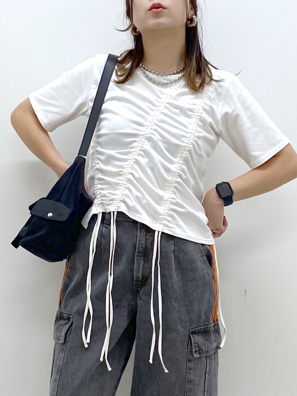 ホワイト系のTシャツ/カットソー、ブラック系のデニムパンツ、ブラック系のスニーカーを着用したレディースの春コーディネートの2枚目の写真