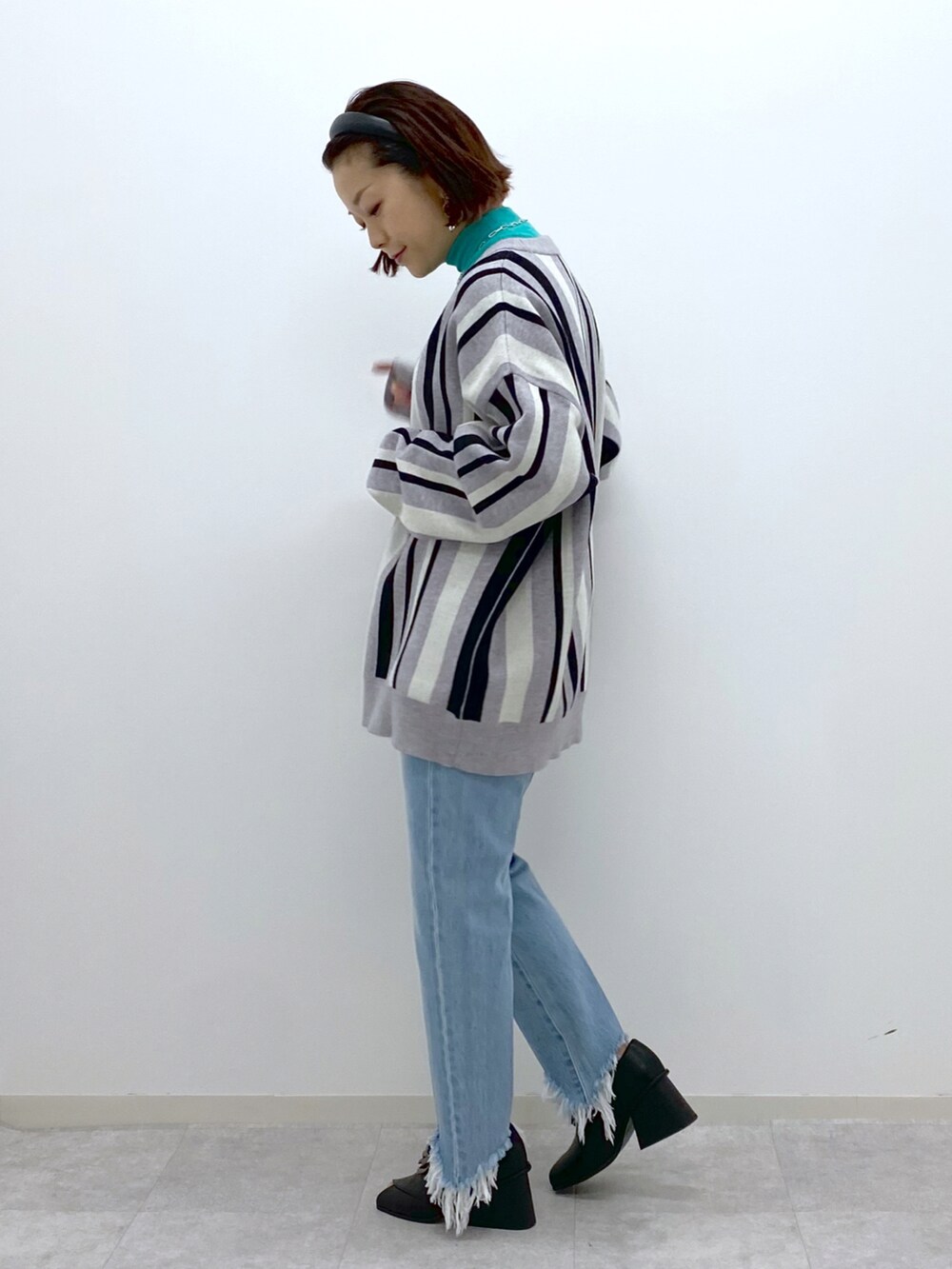 グリーン系のTシャツ/カットソー、ブルー系のデニムパンツ、ブラック系のパンプスを着用したレディースの冬コーディネートの3枚目の写真