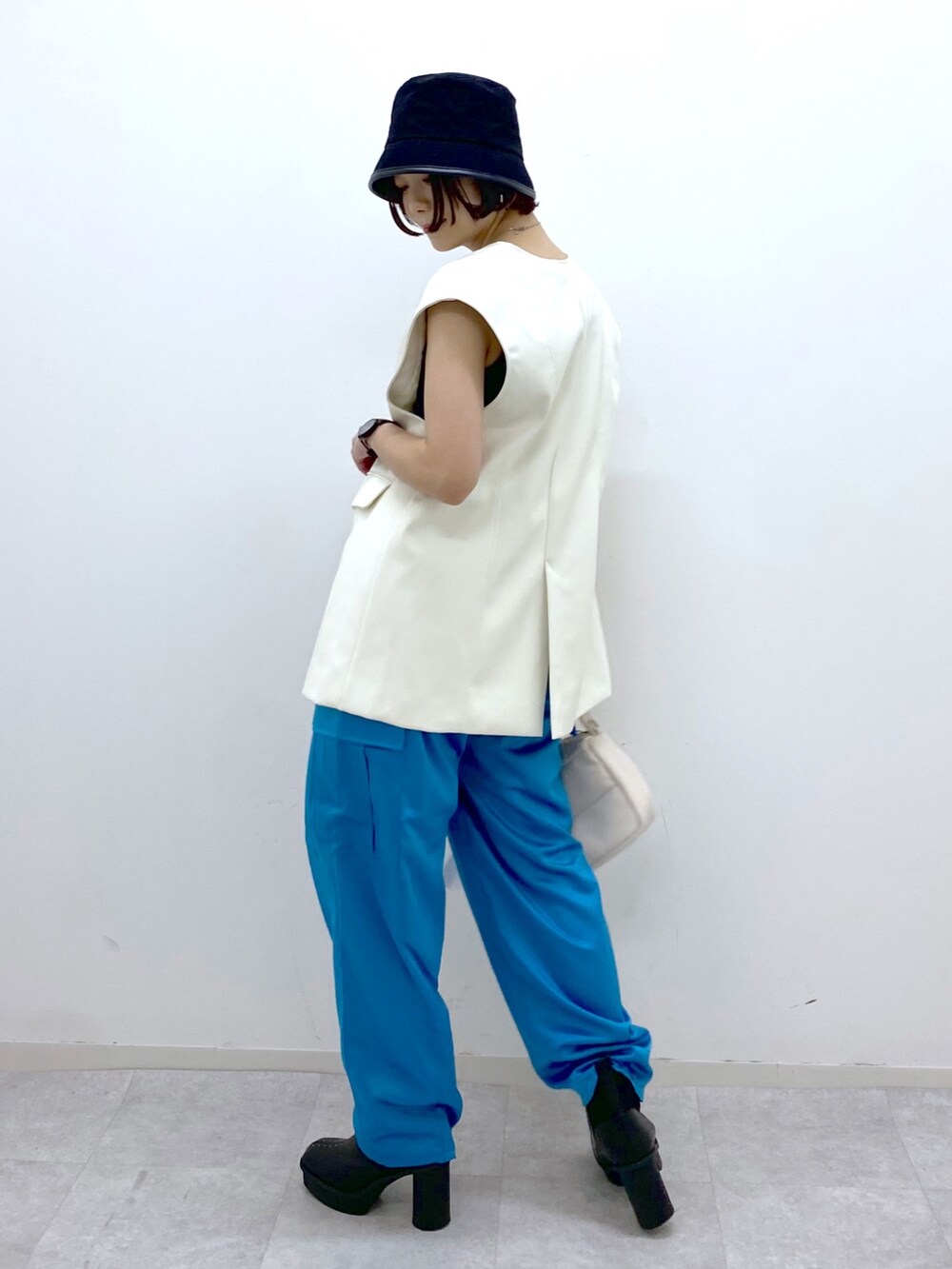 ホワイト系のショルダーバッグ、その他のパンツ、ブラック系のブーツを着用したレディースの秋コーディネートの2枚目の写真