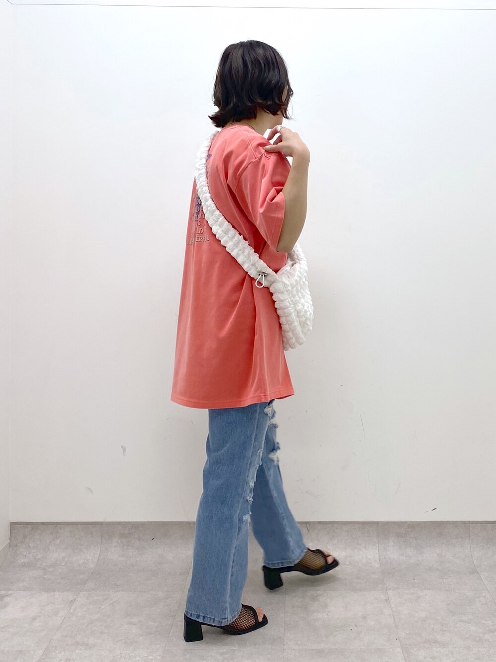 ホワイト系のバッグ、ブルー系のパンツ、レッド系のTシャツ/カットソーを着用したレディースの春コーディネートの3枚目の写真