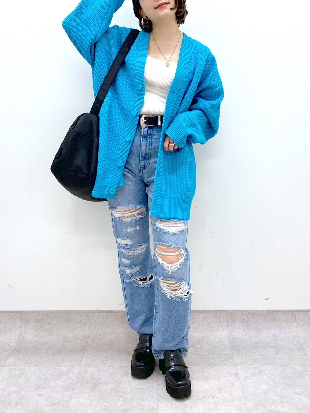 ブラック系のバッグ、ブルー系のパンツ、ブラック系のローファーを着用したレディースの春コーディネートの5枚目の写真