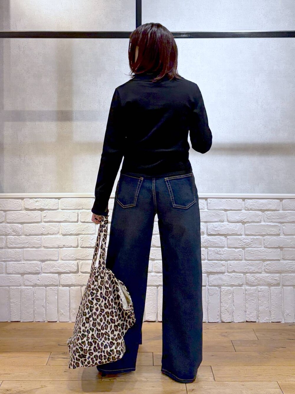 ブルー系のスラックス、ブラック系のサンダル、その他のトートバッグを着用したレディースの冬コーディネートの6枚目の写真