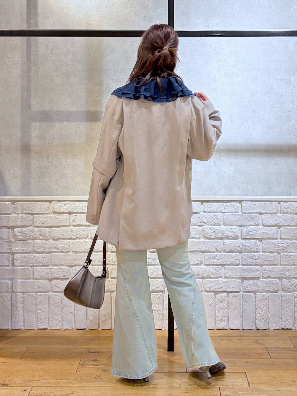 ブラック系のキャミソール、ブルー系のデニムパンツ、ブラウン系のハンドバッグを着用したレディースの春コーディネートの6枚目の写真