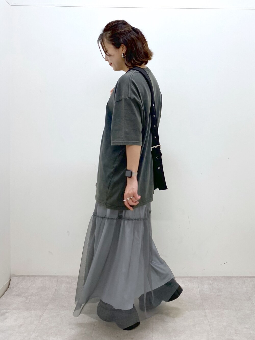 グレー系のTシャツ/カットソー、グレー系のスカート、ブラック系のスニーカーを着用したレディースの夏コーディネートの6枚目の写真