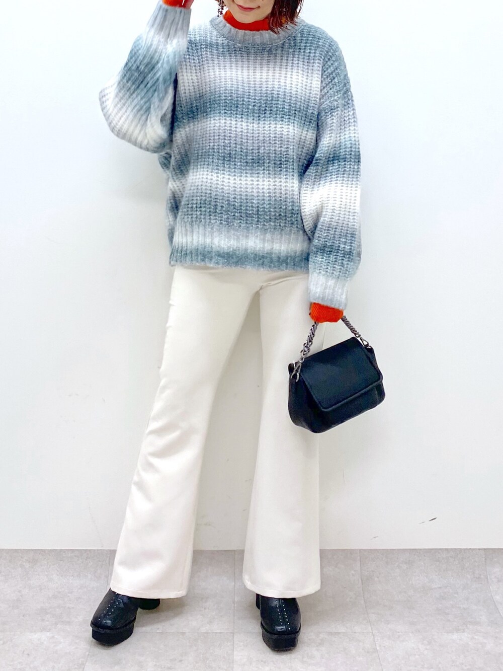 ブラック系のトップス、オレンジ系のトップス、ブラック系のバッグを着用したレディースの秋コーディネートの5枚目の写真