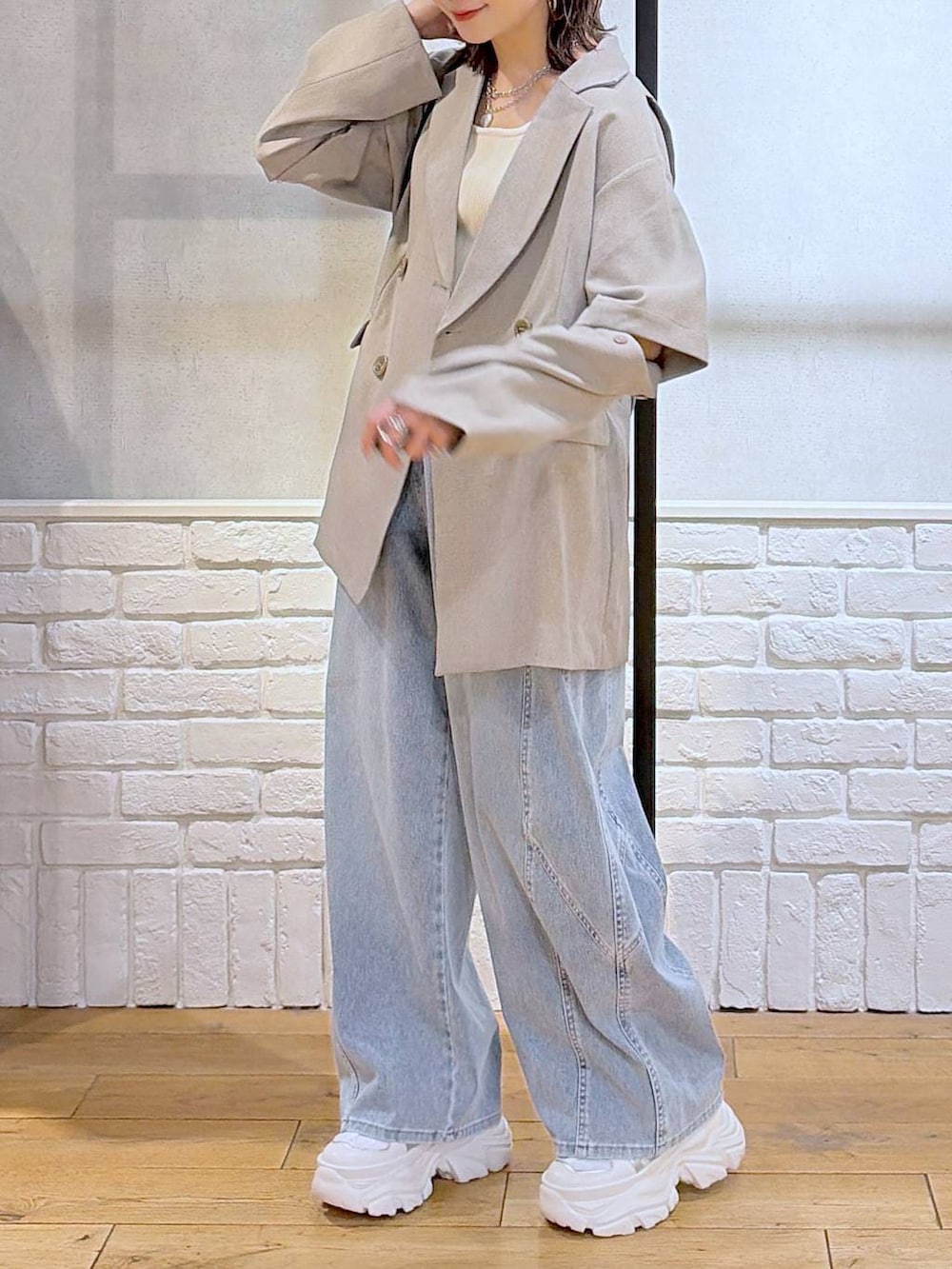 ホワイト系のスニーカー、ホワイト系のタンクトップ、ブラウン系のショルダーバッグを着用したレディースの春コーディネートの3枚目の写真